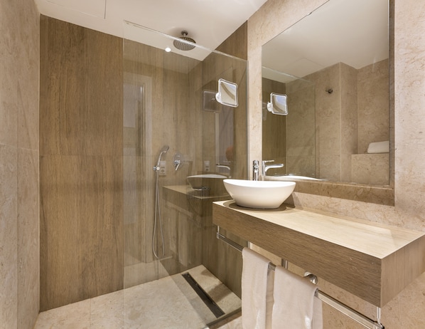A modern bathroom with a glass-enclosed shower, a white vessel sink, and a large mirror. - Apartamentos Sinfony (Capdepera)