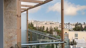 A view from a balcony with a metal railing, overlooking a cityscape with historical buildings and a mosque.