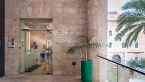 A stone building entrance with a sign reading "216B King David Street" and a potted plant.