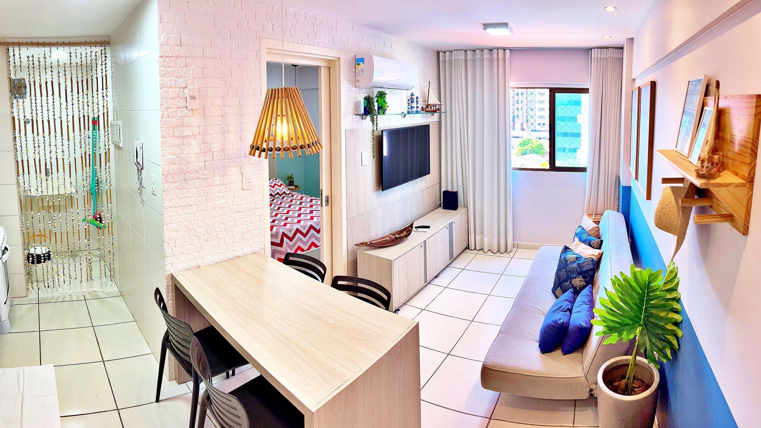A modern living room with a sofa, TV, and a dining area with chairs and a table.