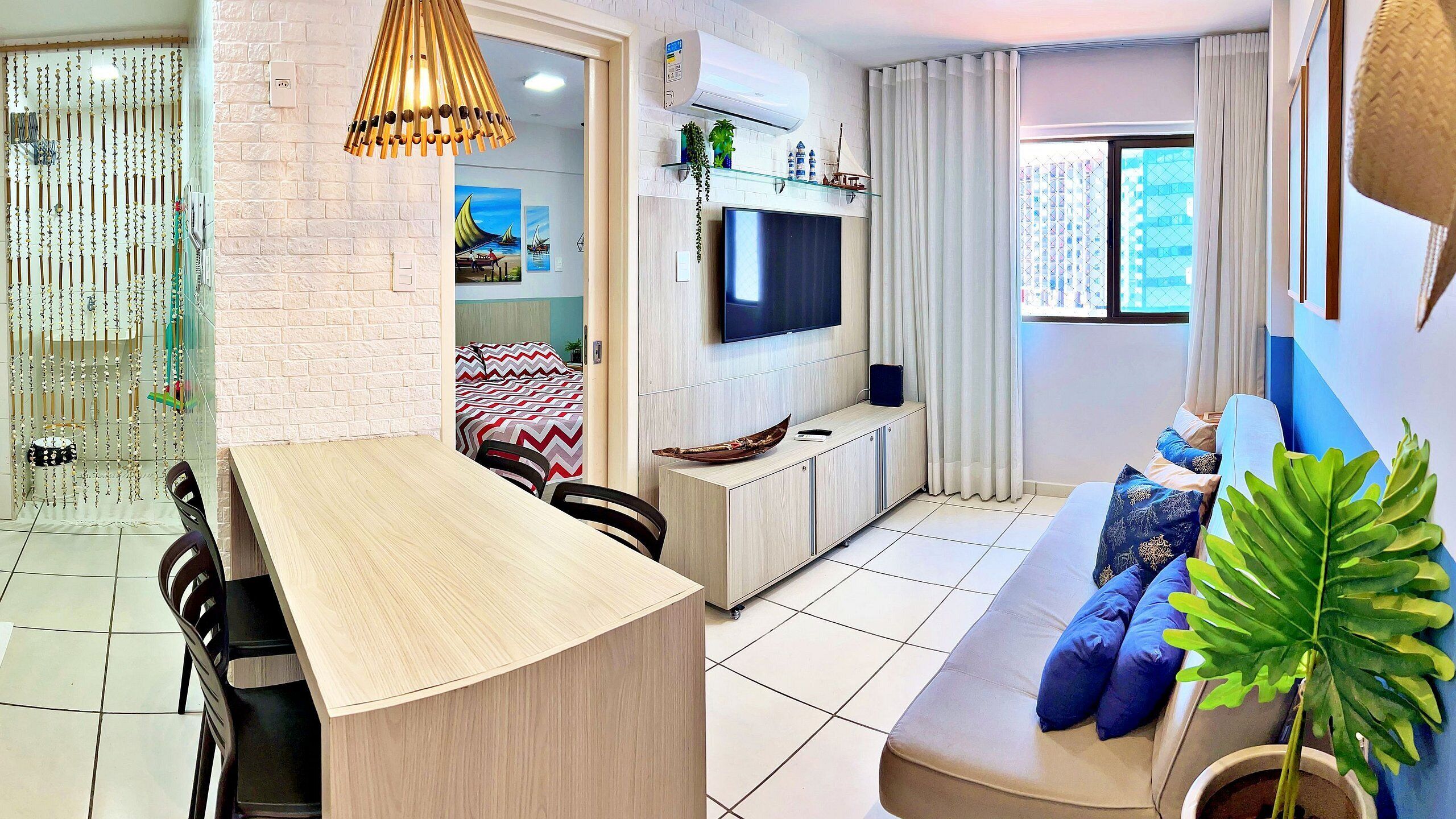 A modern living room with a sofa, TV, and dining area.