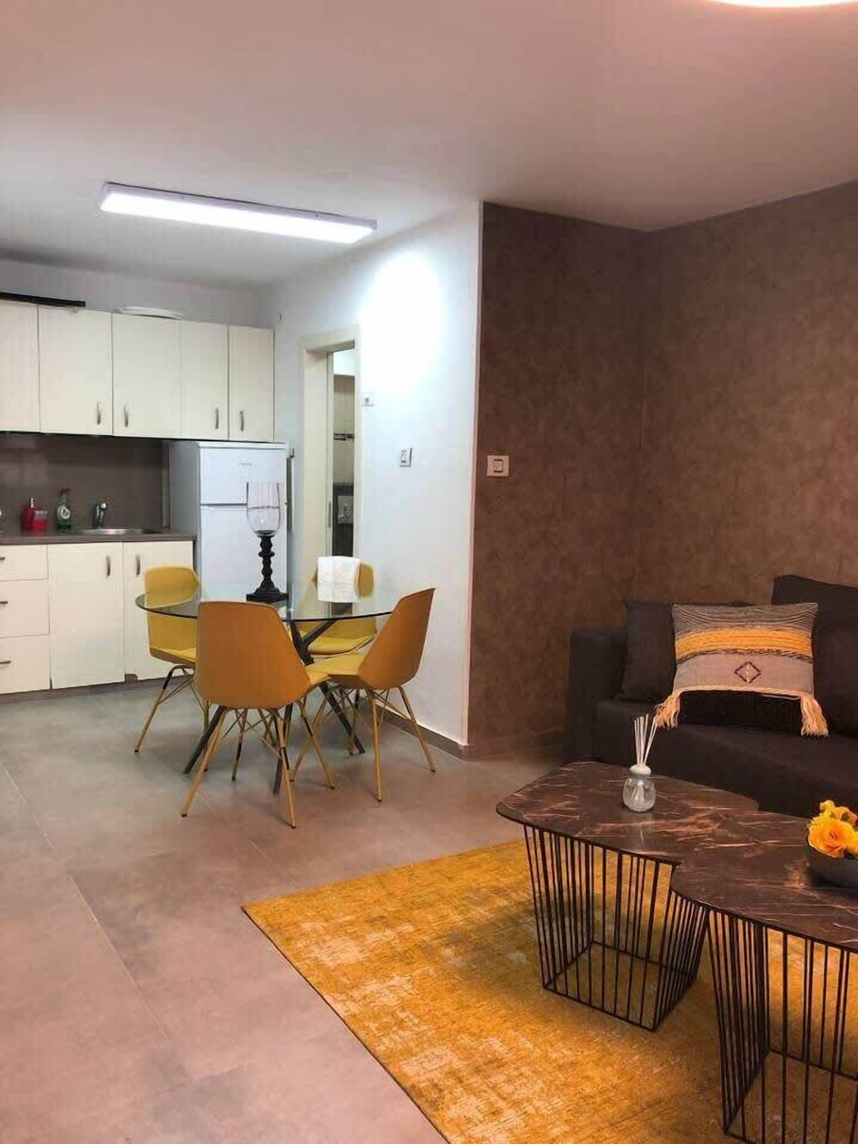 A compact living space with a kitchen, dining area, and a seating area with a sofa and coffee table.