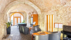 A cozy, brick-walled room with a pool table, a piano, and comfortable seating. - Hapimag Resort Budapest (Budapest)