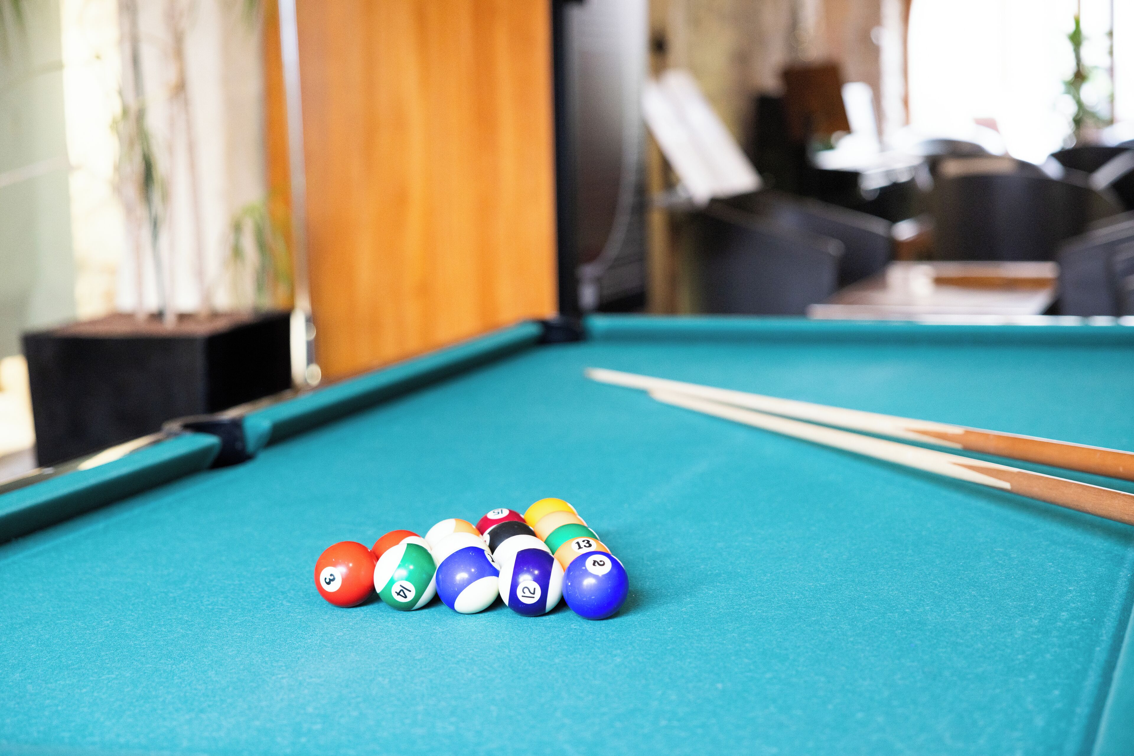A pool table with billiard balls and cues.