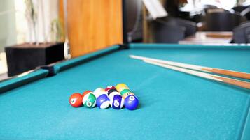 A pool table with billiard balls and cues.