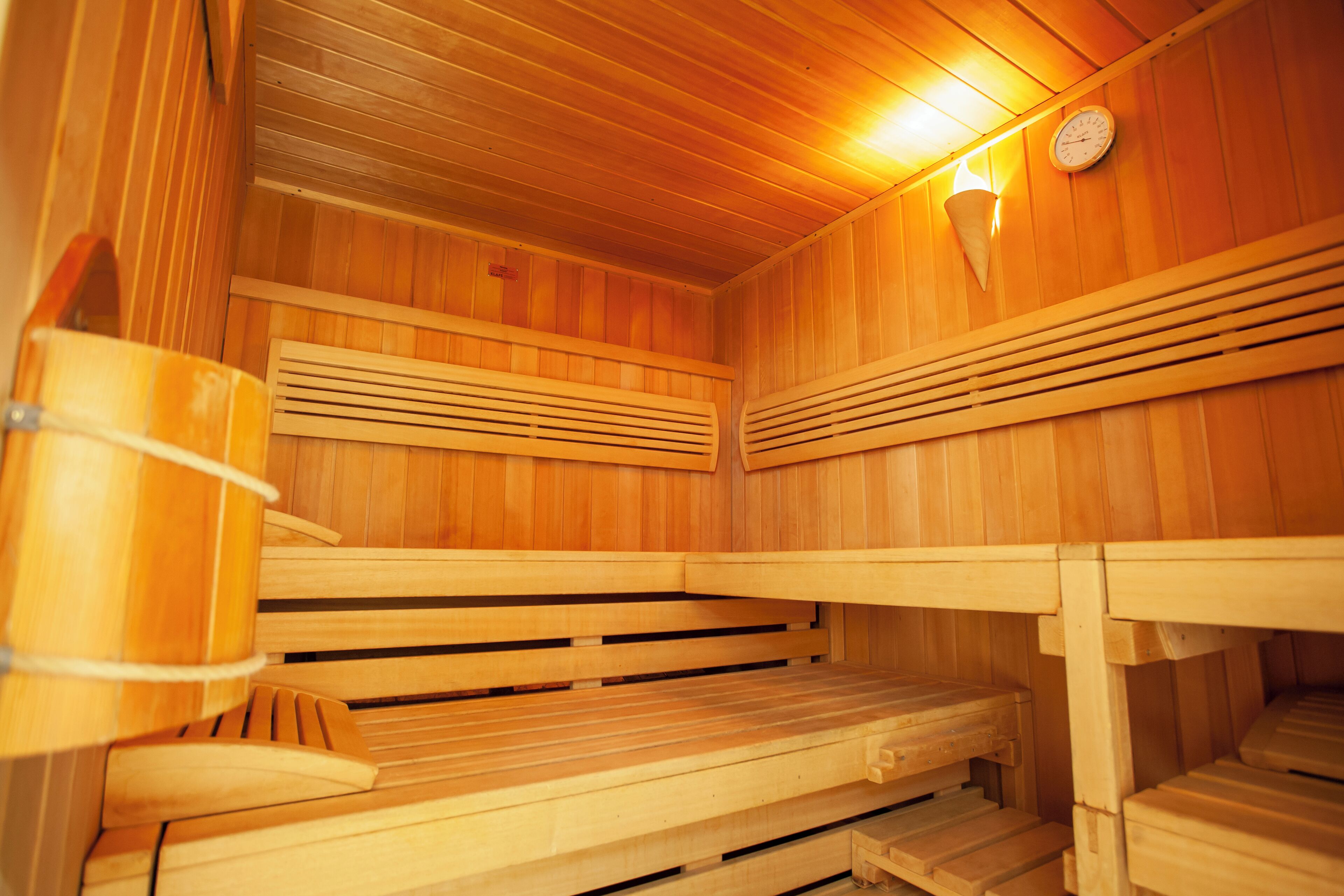 Un sauna avec des bancs en bois et un plafond incliné.