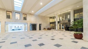 A spacious lobby with a tiled floor, large windows, and a car parked outside.