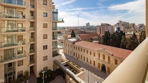 A multi-story building with balconies, a courtyard, and a view of the cityscape.