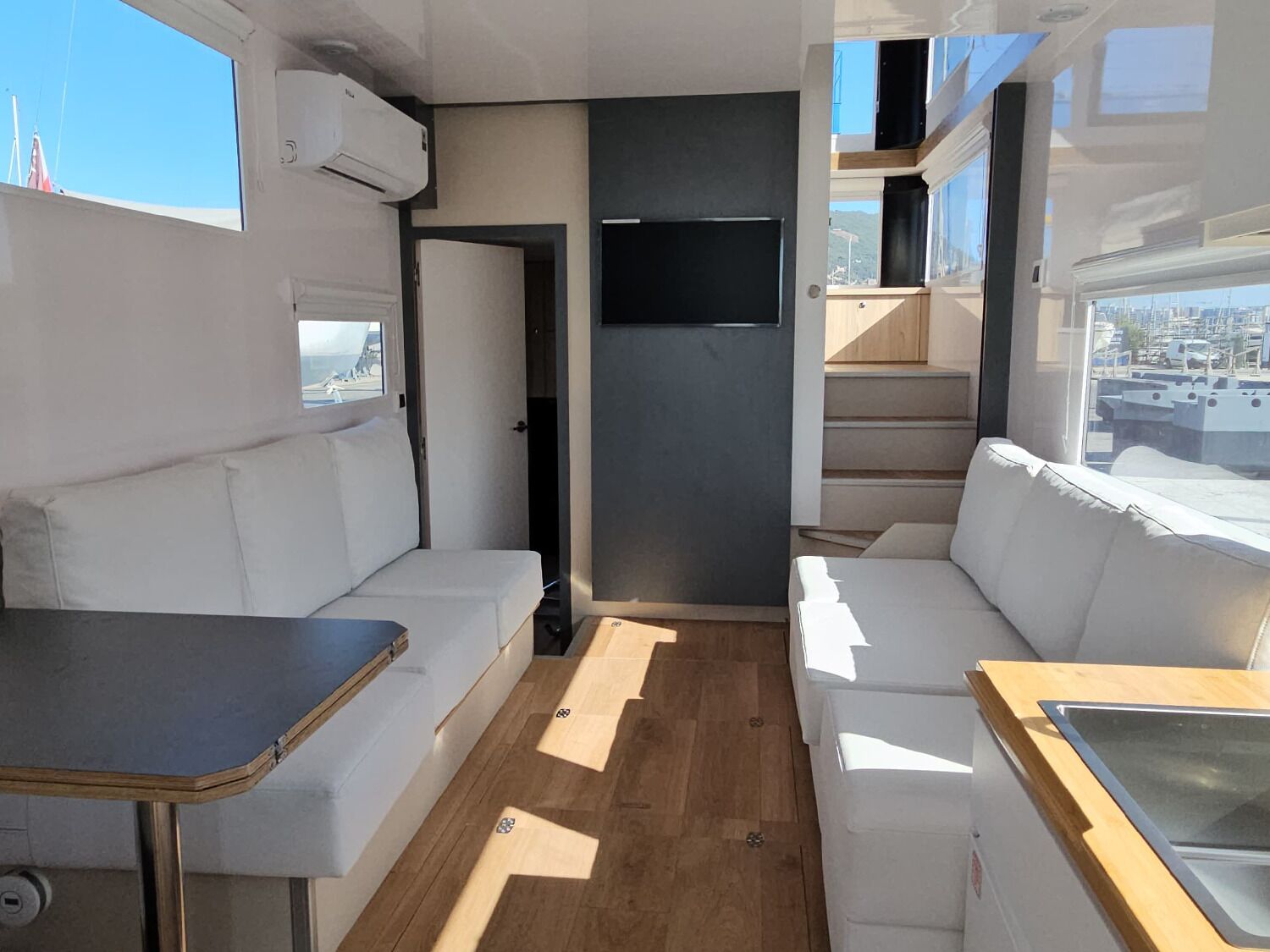 An RV interior with a sofa, a small table, and a kitchenette area.