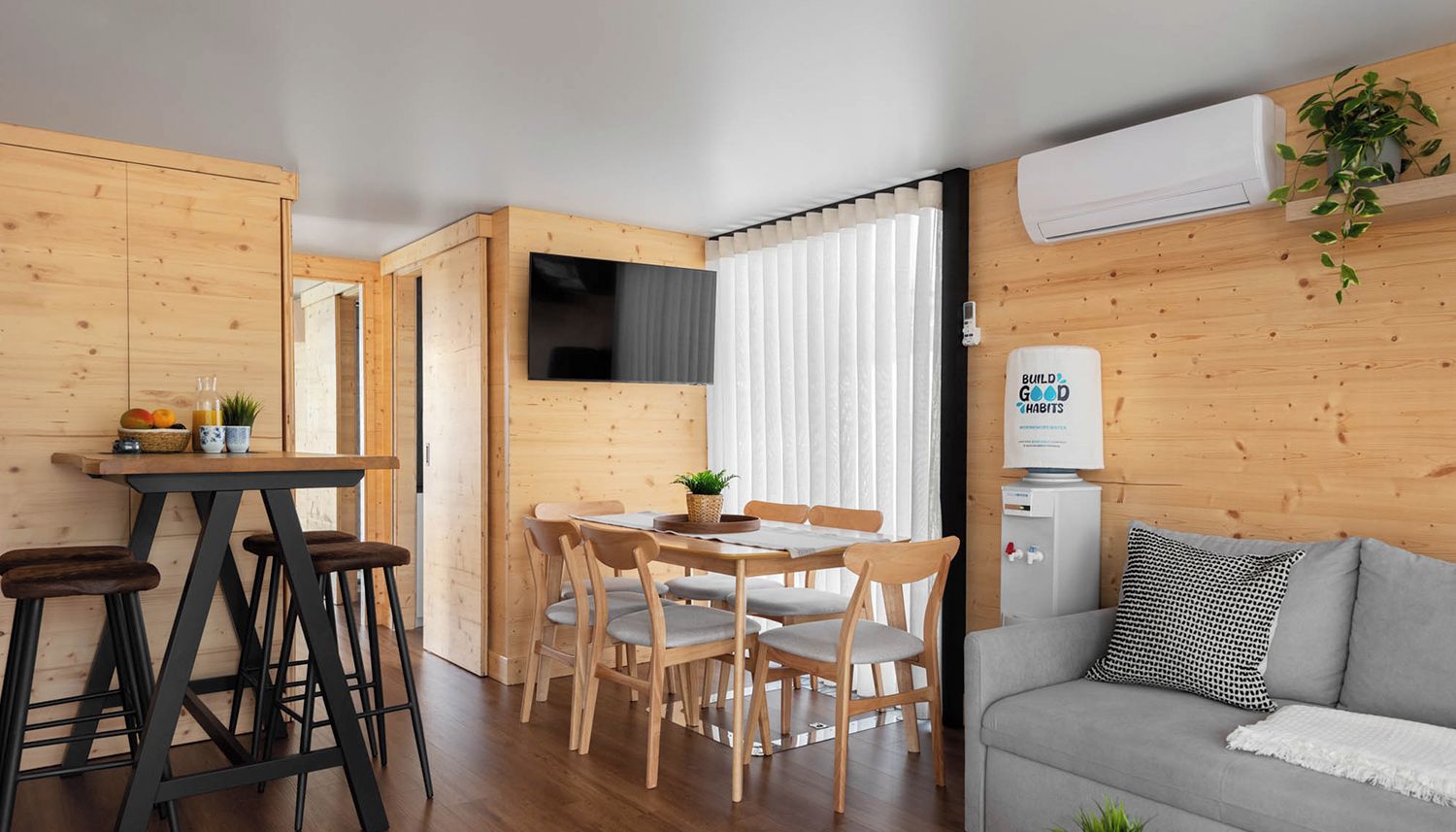 A compact living space with a dining area, a sofa, and a kitchenette.