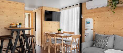 A compact living space with a dining area, a sofa, and a kitchenette.