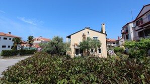 A residential building with a beige facade, a chimney, and a balcony with a railing. - ROKOV Two-Bedroom Apartment (Rovinj)