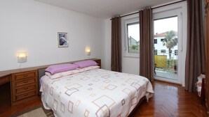 A bedroom with a bed, a nightstand, a dresser, and a window with curtains. - ROKOV Two-Bedroom Apartment (Rovinj)