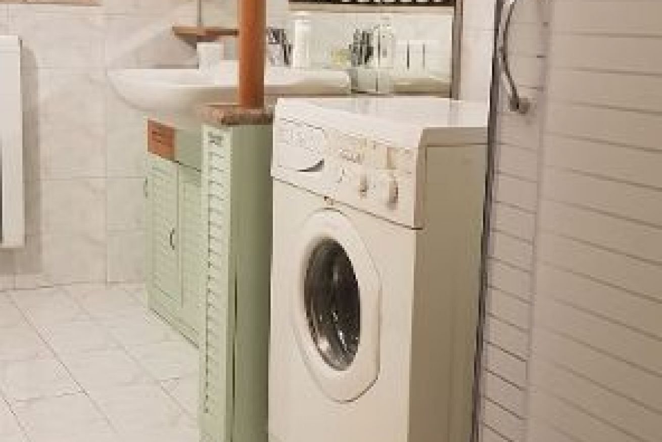 A laundry area with a washing machine, a dryer, and a sink.