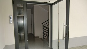 An open door leading to a hallway with a staircase and a security keypad on the wall. - Bnbook Don Sturzo with super wi fi (Cornaredo)