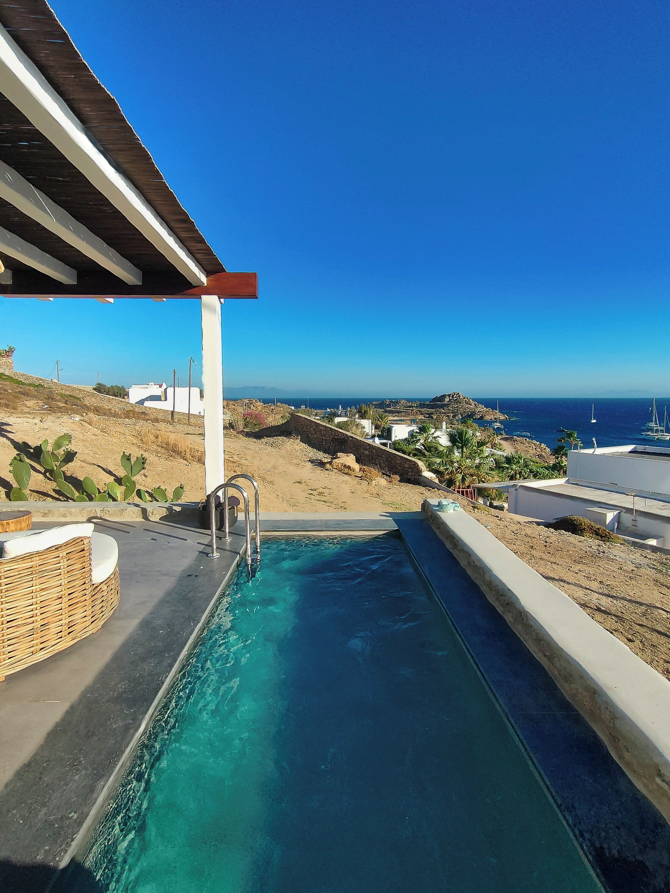 A swimming pool with a view of the sea and buildings in the background.