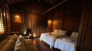 Um quarto aconchegante com duas camas, um sofá e uma poltrona de massagem.