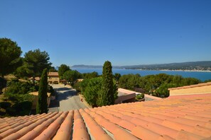 Blick auf die Küste von einem Gebäude mit Terrakotta-Dach, das einen Strand und das Meer überblickt.