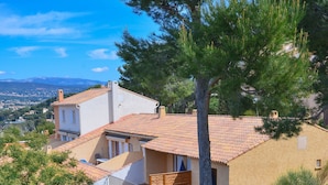A multi-story building with a terracotta roof, balconies, and a garden area. - VVF Résidence Saint-Cyr-sur-Mer (Saint-Cyr-sur-Mer)