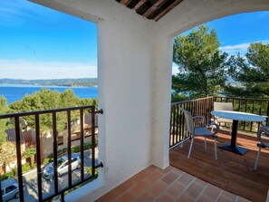 Ein Balkon mit Blick auf das Meer, inklusive Tisch und Stühlen.