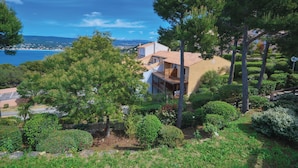A coastal property with a modern house surrounded by lush greenery and a view of the sea. - VVF Résidence Saint-Cyr-sur-Mer (Saint-Cyr-sur-Mer)