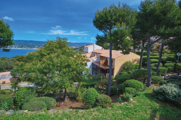 Ein Küstenanwesen mit einem modernen Haus, umgeben von üppiger Vegetation und Blick aufs Meer.