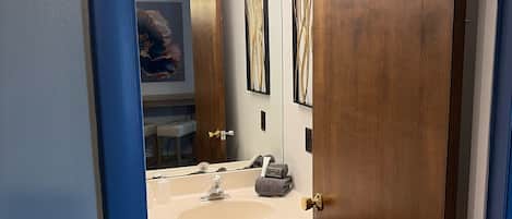Un baño con tocador de madera, un lavabo y un espejo.