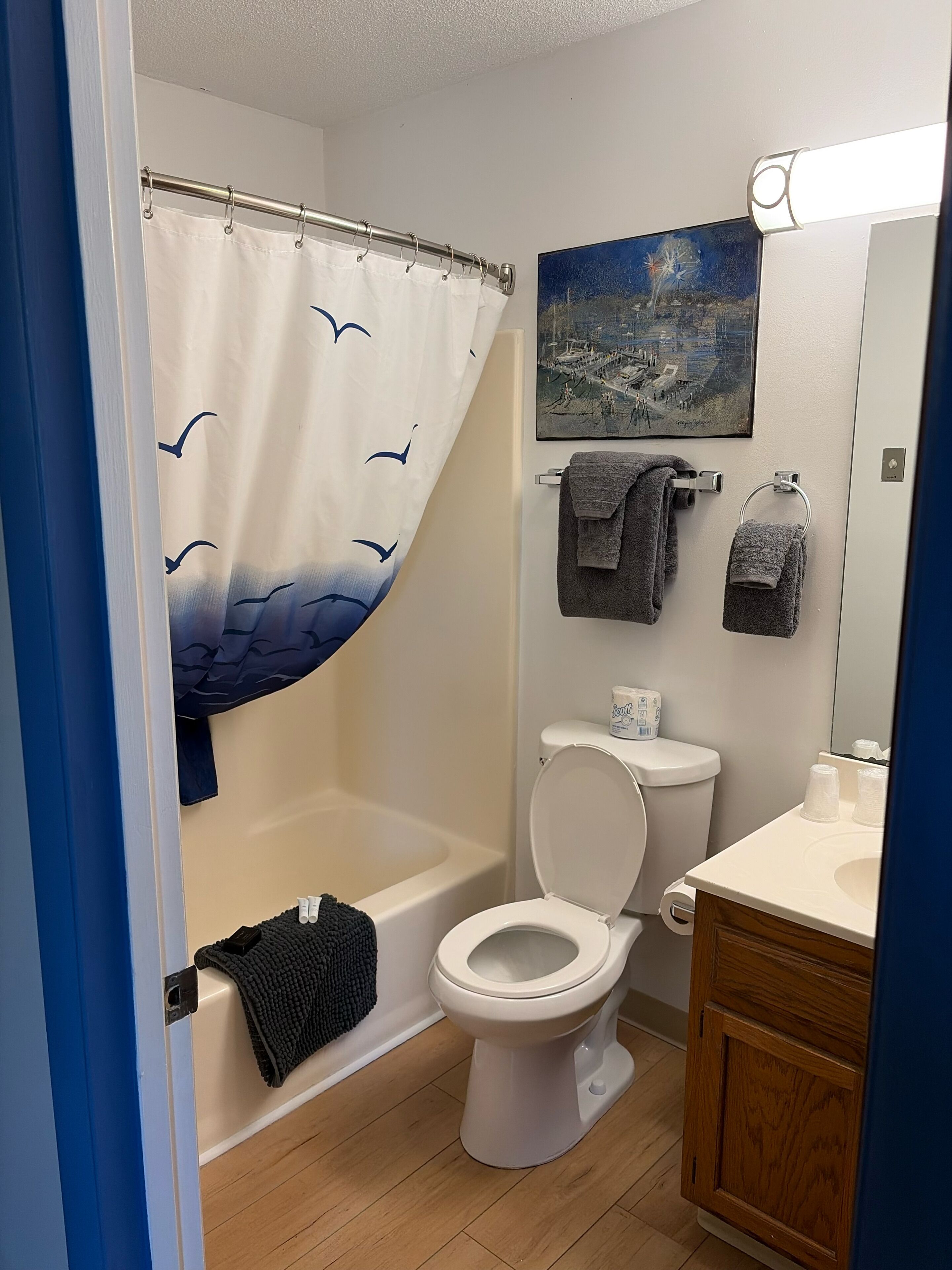 Un baño con cortina de ducha, inodoro, bañera, lavabo y toallero.