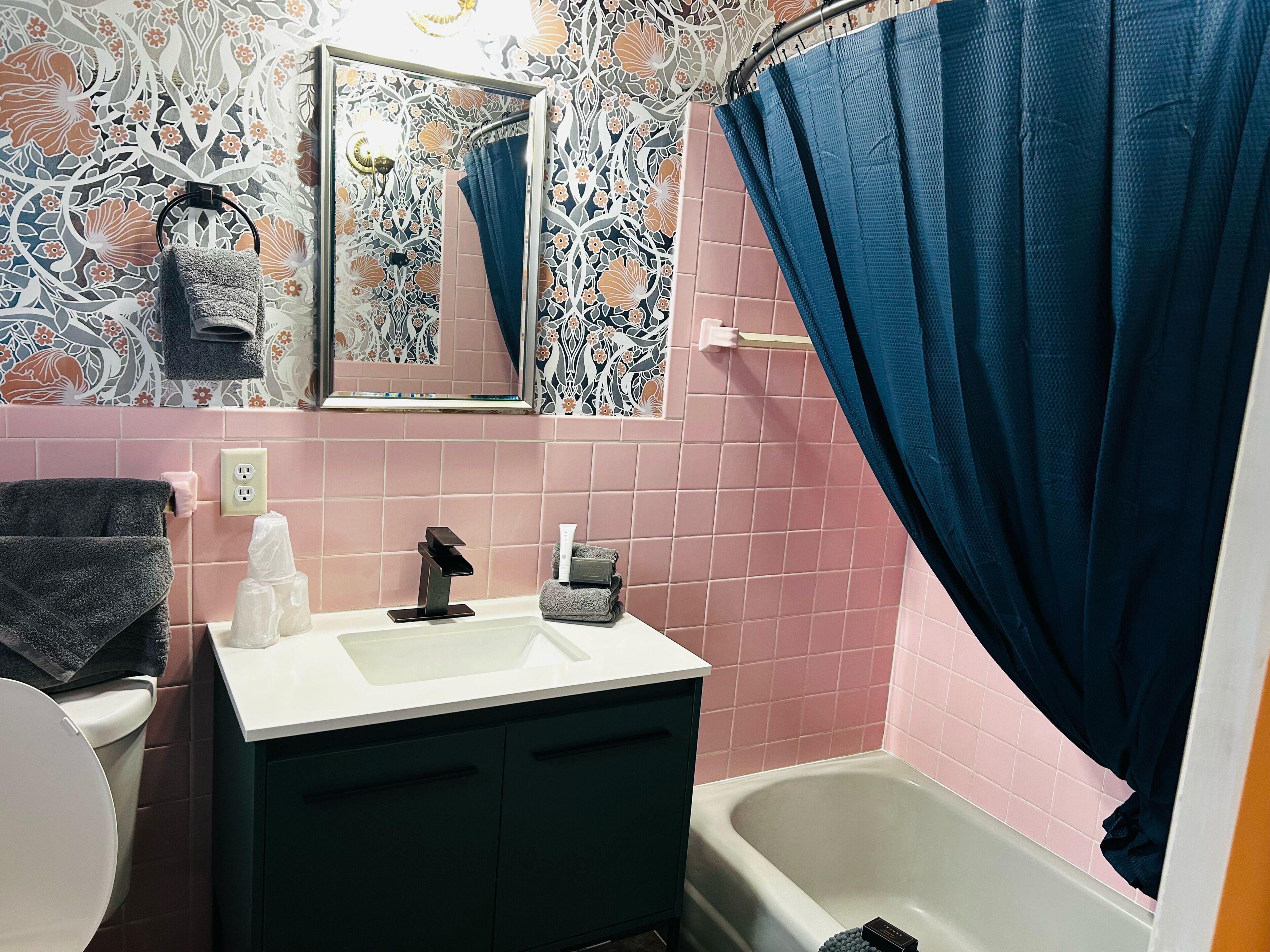 A bathroom with a sink, mirror, and bathtub.