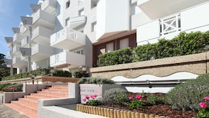 A multi-story hotel with balconies, a staircase, and a sign reading "Ville d'Ete". - VVF Résidence Arcachon (Arcachon)