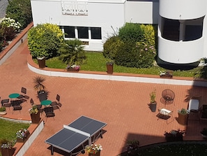 An outdoor area with a ping pong table, several chairs, and potted plants. - VVF Résidence Arcachon (Arcachon)
