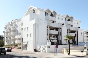 A modern white building with multiple balconies and a sign indicating directions to Front de Mer and Embarcadero. - VVF Résidence Arcachon (Arcachon)