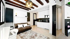 Un appartement moderne comprenant un espace de vie, une kitchenette et une chambre.