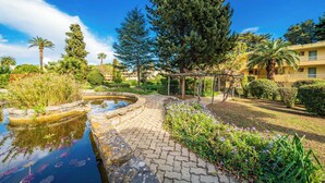 A garden with a pond, pathway, and a pergola. - Hello Côte d'Azur - Spacious apartments at a 5 min walk from the beach (Antibes)