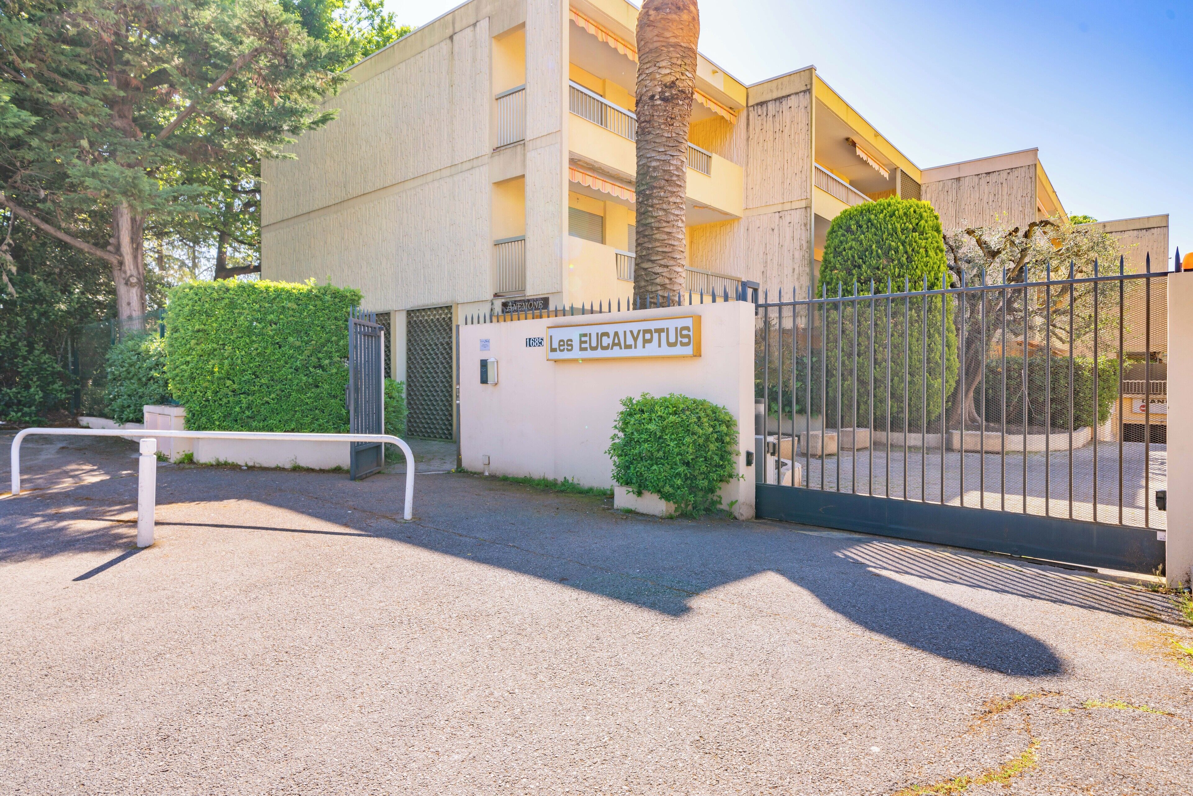 A gated entrance to a building with a sign reading "Les Eucalyptus."