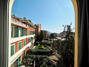 Une cour offrant une vue sur les bâtiments, un jardin bien entretenu et un ciel dégagé.