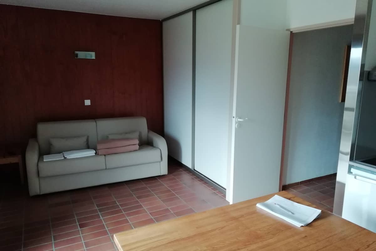Ein Zimmer mit einer Couch, einem Holztisch und einer Schiebetür.