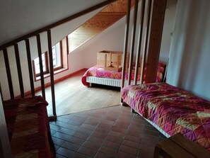 A dormitory room with two beds, wooden bunk beds, a window, and a sloped ceiling. - VVF Résidence Les Angles Pyrénées (Les Angles)
