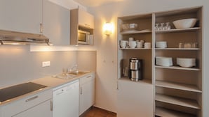 A modern kitchen with white cabinetry, a Bosch range hood, a built-in microwave, and a dish rack. - VVF Résidence Les Angles Pyrénées (Les Angles)