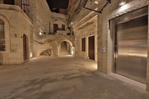 Un edificio de piedra con ascensor, arcos y una escalera.