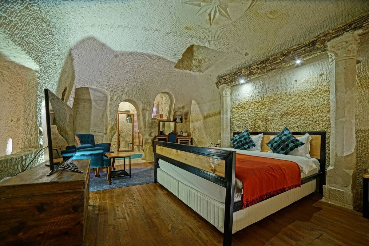 Une pièce avec un lit, des meubles en bois et des murs en pierre.