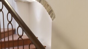 Una escala amb graons marrons i barana metàl·lica.