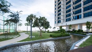 A modern building with a landscaped garden, a curved pathway, and a small water feature. - Miko's Home (Shah Alam)