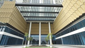 A modern building with a central atrium, large glass windows, and a patterned facade. - Miko's Home (Shah Alam)