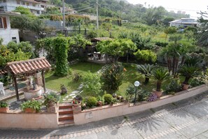 A garden with a gazebo, potted plants, and a small patio area. - B&B Valeri (Tropea)