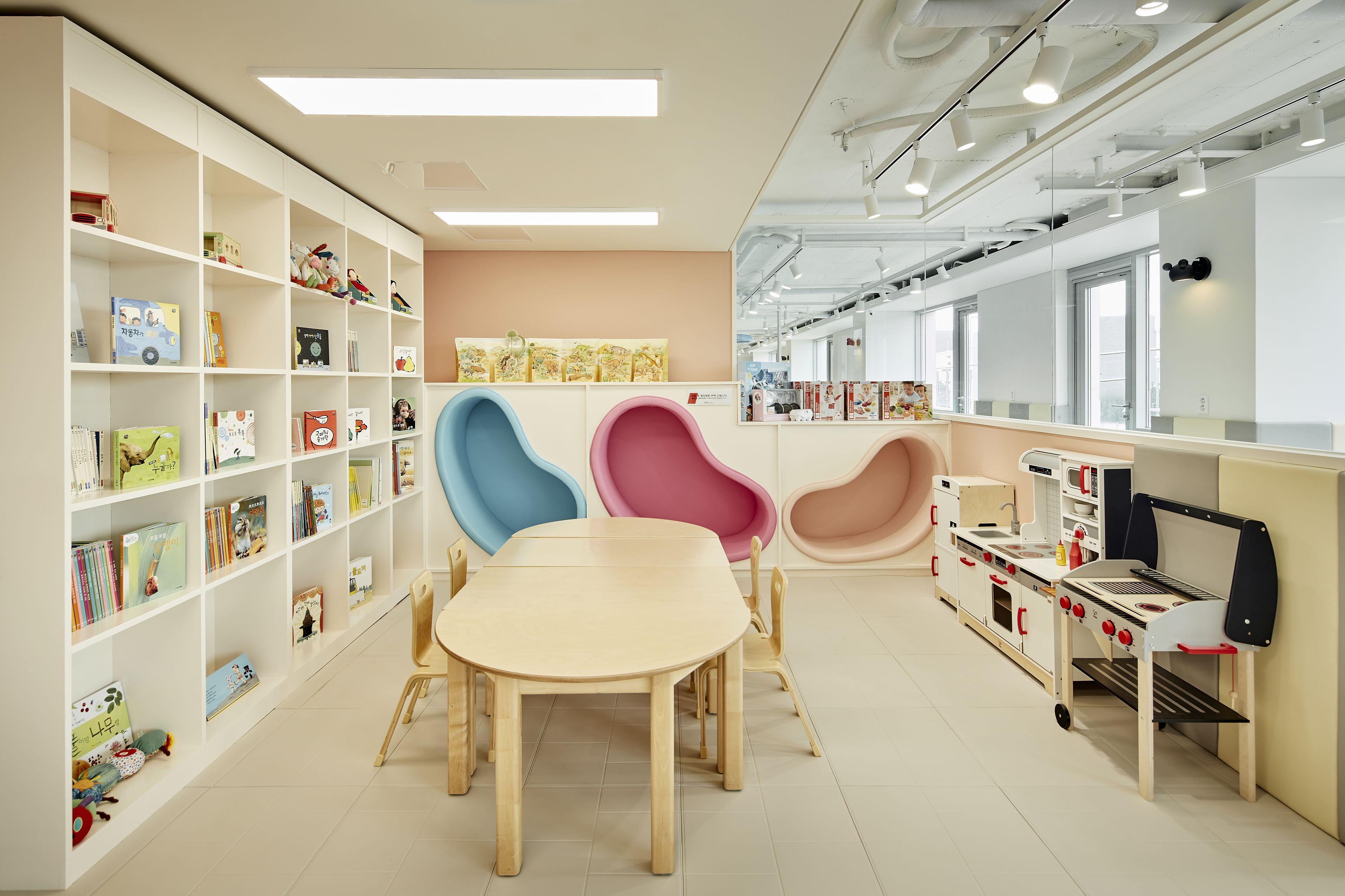 A children's play area with a table, chairs, and a play kitchen.