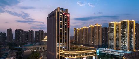 A high-rise hotel with a modern design, featuring a prominent entrance and a large digital billboard.