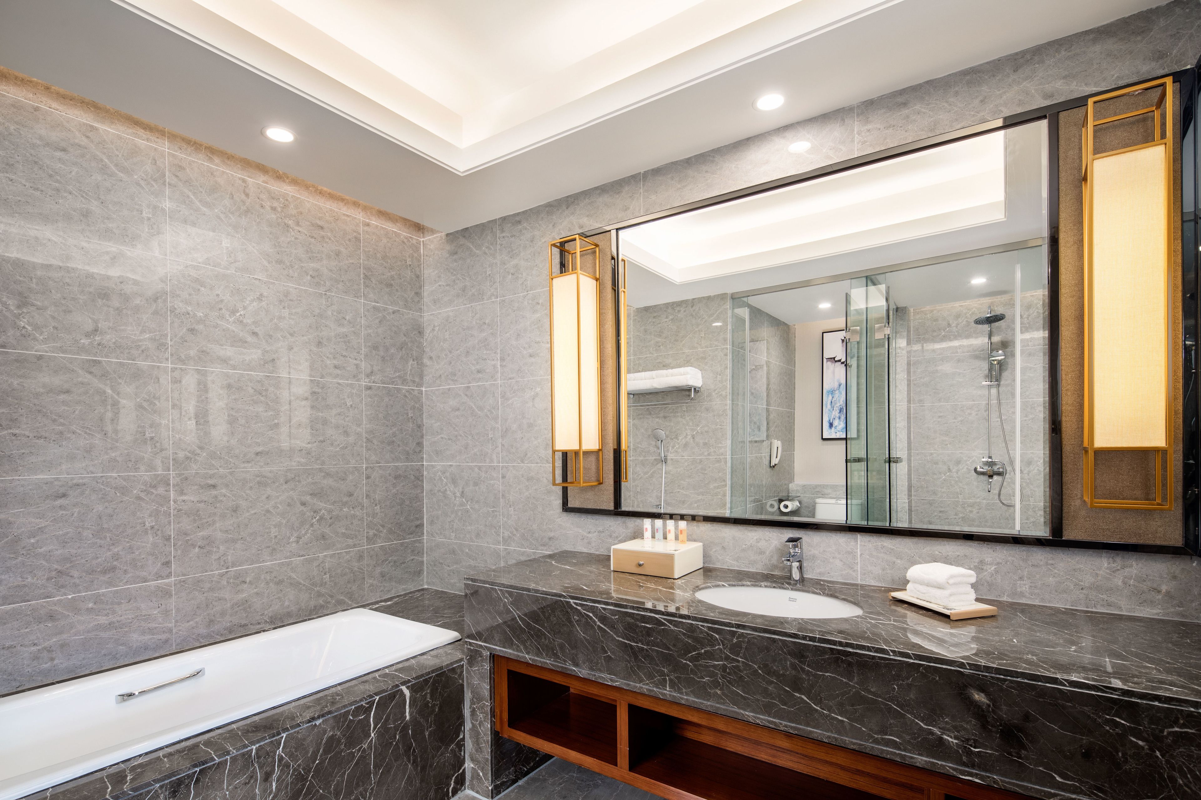 Un baño moderno con un espejo grande, una bañera y un tocador con lavamanos.