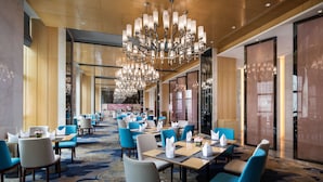 A hotel lobby with a large chandelier, blue and white seating, and a patterned carpet. - Ramada by Wyndham Wuhan Hanyang (Wuhan)