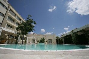 Una piscina al aire libre de temporada, sillones reclinables de piscina